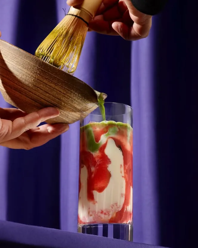 Whisking matcha into a strawberry drink